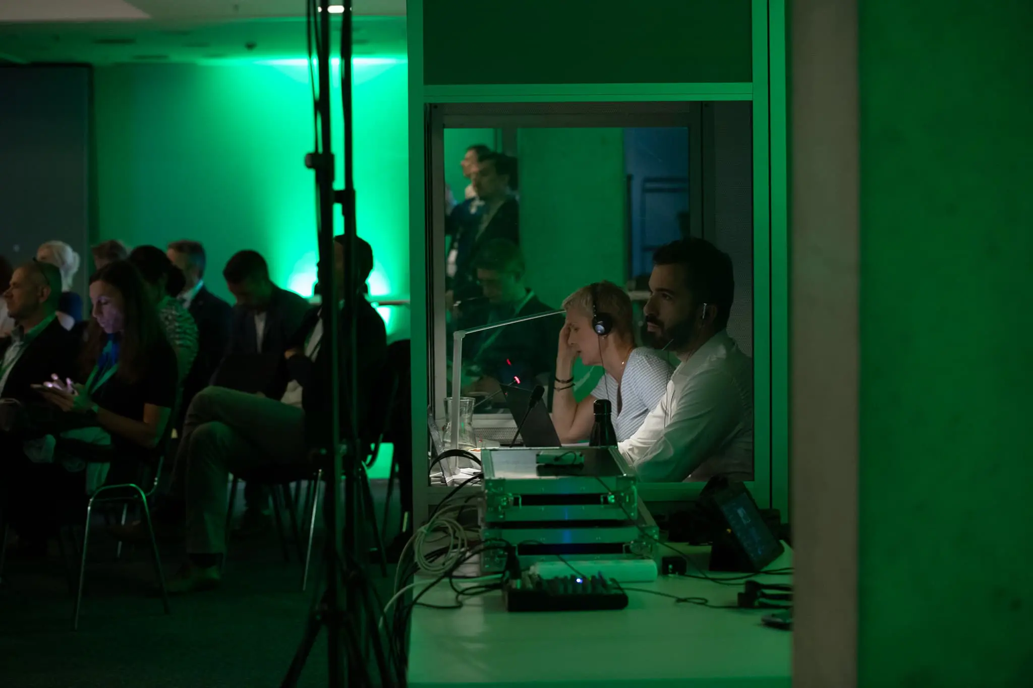 Simultaneous interpreting booth with interpreter team coordinating multilingual conference coverage